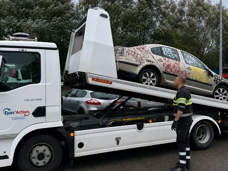 Camion plateau Epav'Action chargeant un véhicule hors d'usage